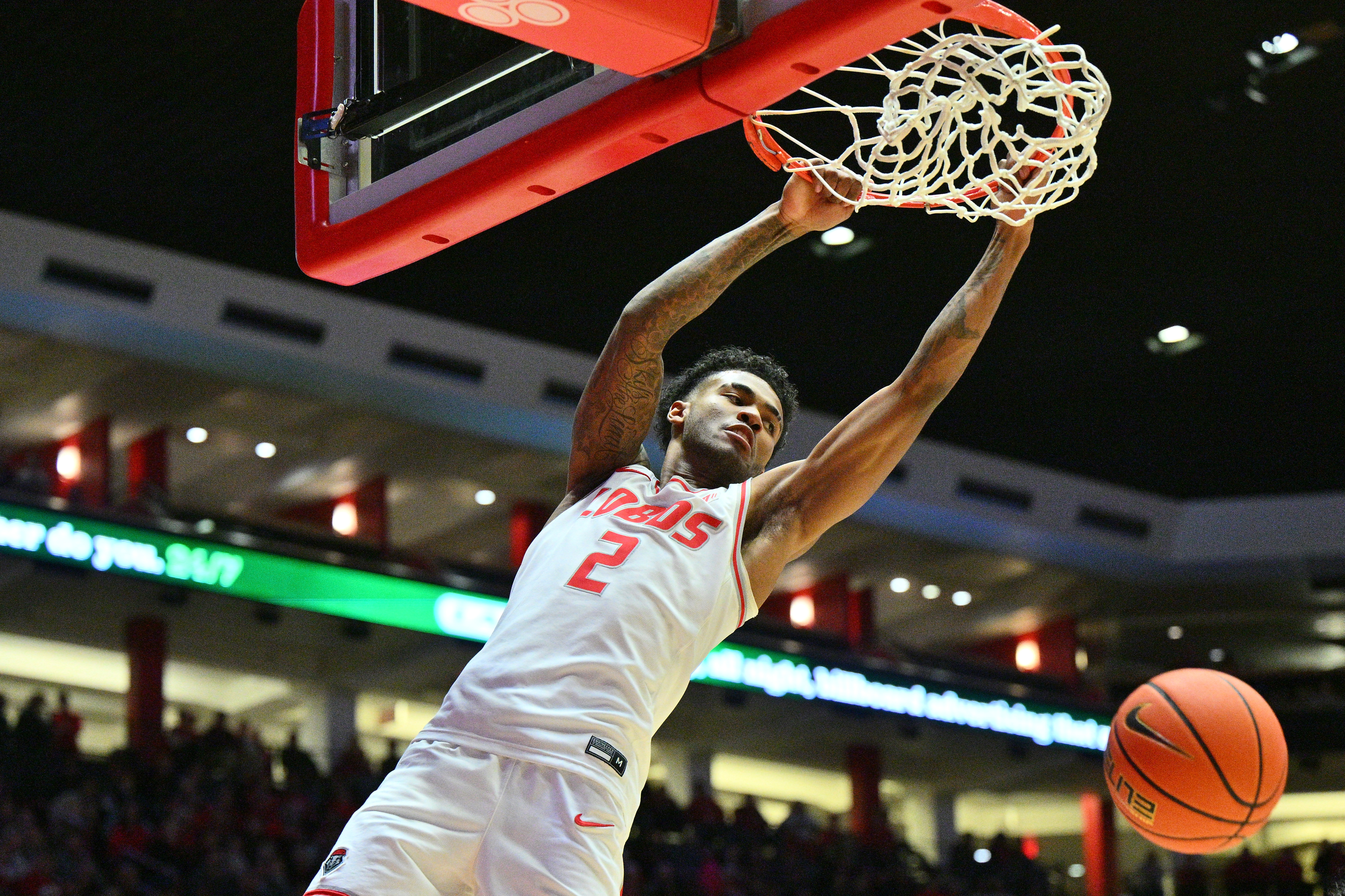 New Mexico basketball player Donavant Dent dunks